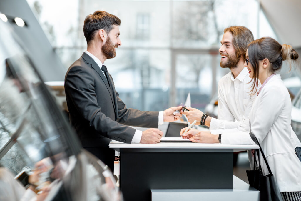 Business couple at the stand with salesperson in the showroom