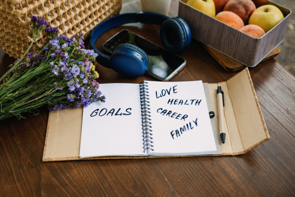 New Years Resolutions Goals motivational phrase in open notebook on the table. Outdoor still life